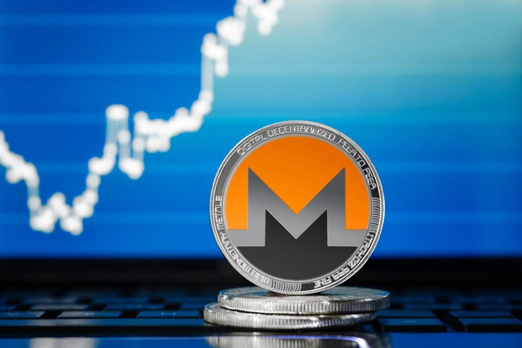 monero coin above laptop keyboard